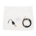 A Prada black leather strap with gold-tone hardware, displayed next to its white branded dust bag