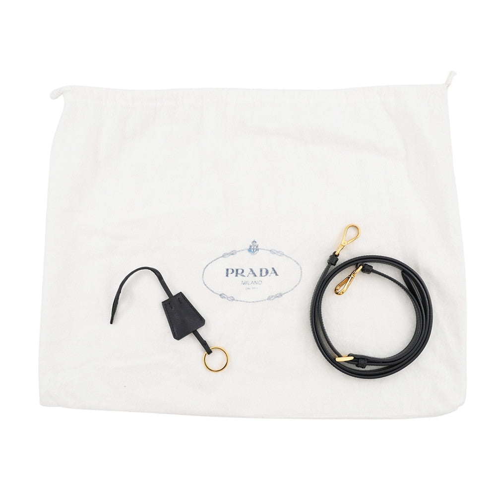 A Prada black leather strap with gold-tone hardware, displayed next to its white branded dust bag