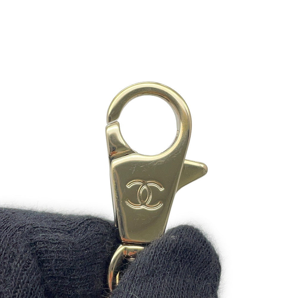 A close up of Chanel Coco handle gold-tone metal lobster clasp with an engraved interlocking Brand CC logo