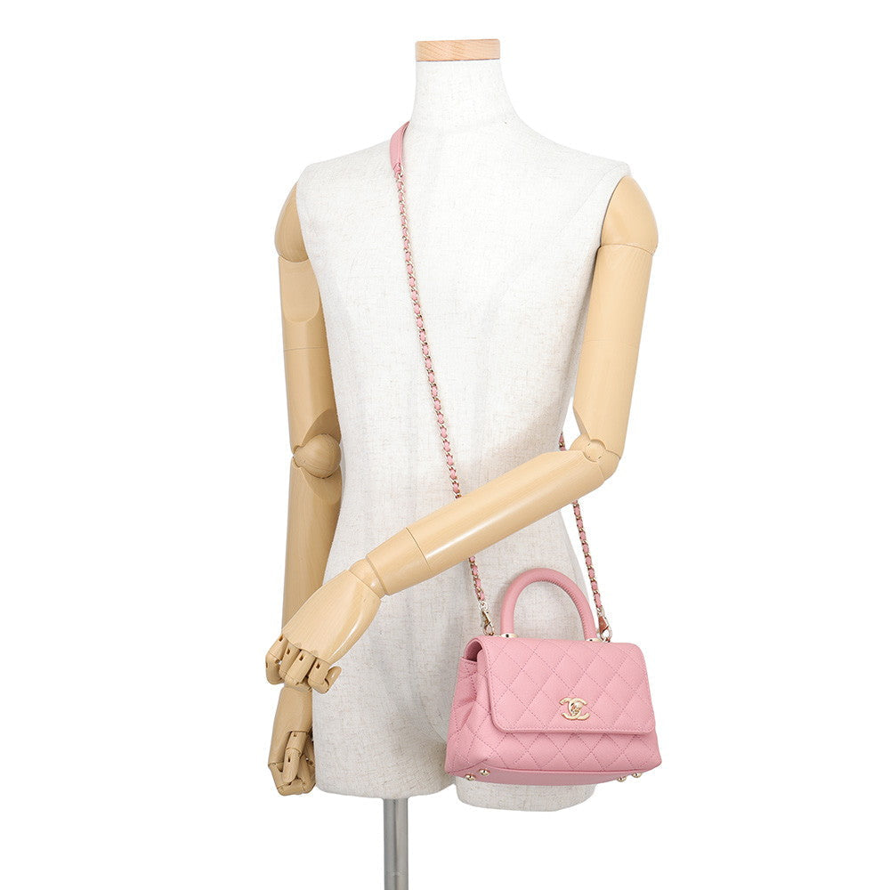 CHANEL Coco Handle Mini in Pink Caviar Leather with Gold-Tone Hardware Displayed as a crossbody bag worn over the mannequin 