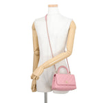 CHANEL Coco Handle Mini in Pink Caviar Leather with Gold-Tone Hardware Displayed as a crossbody bag worn over the mannequin 