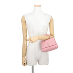 CHANEL Coco Handle Mini in Pink Caviar Leather with Gold-Tone Hardware displayed on a beige mannequin torso against a white background.