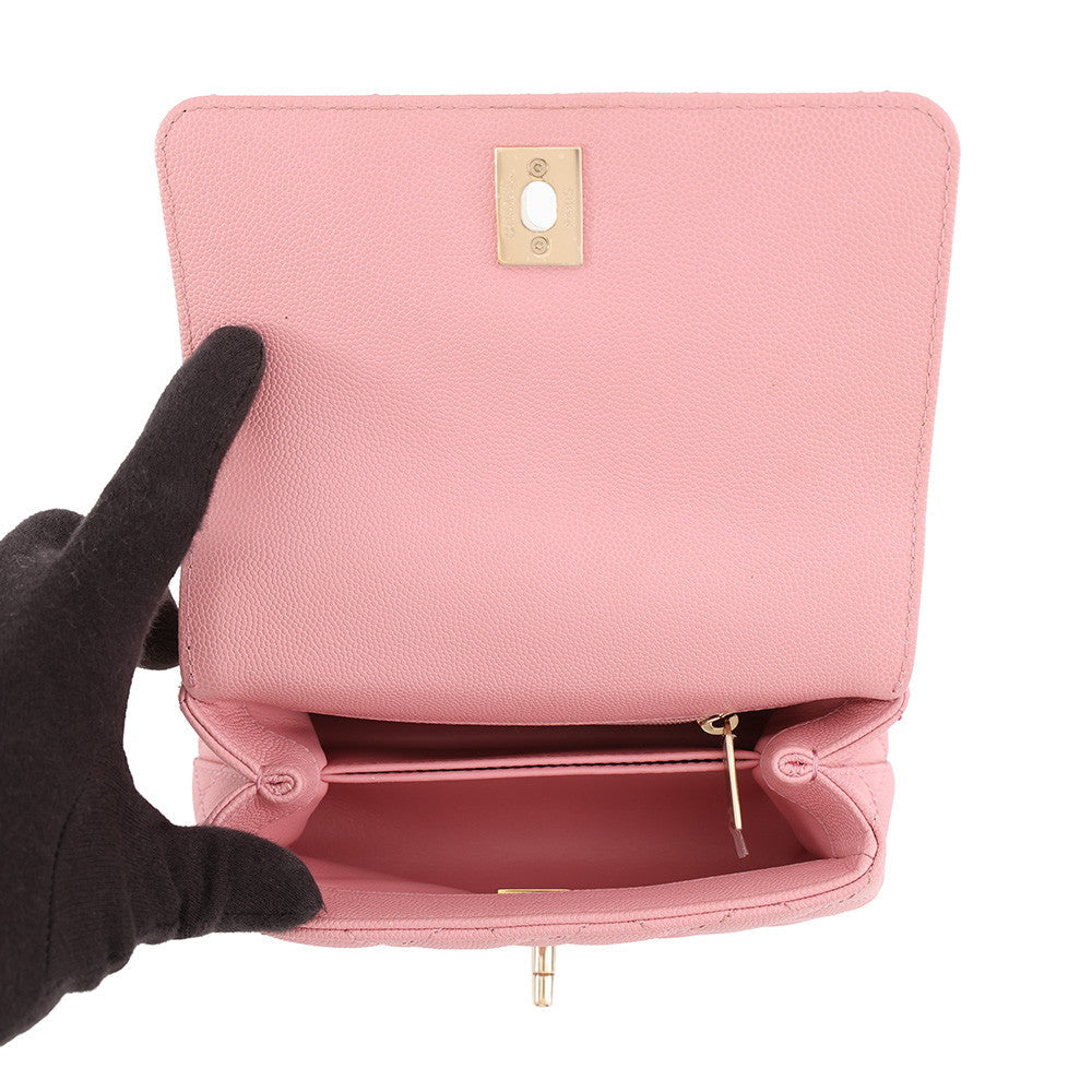 Close-up of CHANEL coco mini  handle bag in caviar leather handbag displaying the interior. The bag has a gold-tone metal clasp on the inside flap and a zippered compartment.