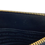 Close-up of the interior of a Prada saffiano Galleria showing black interior Bag Lining with gold-tone zipper trim and embossed Prada branding.