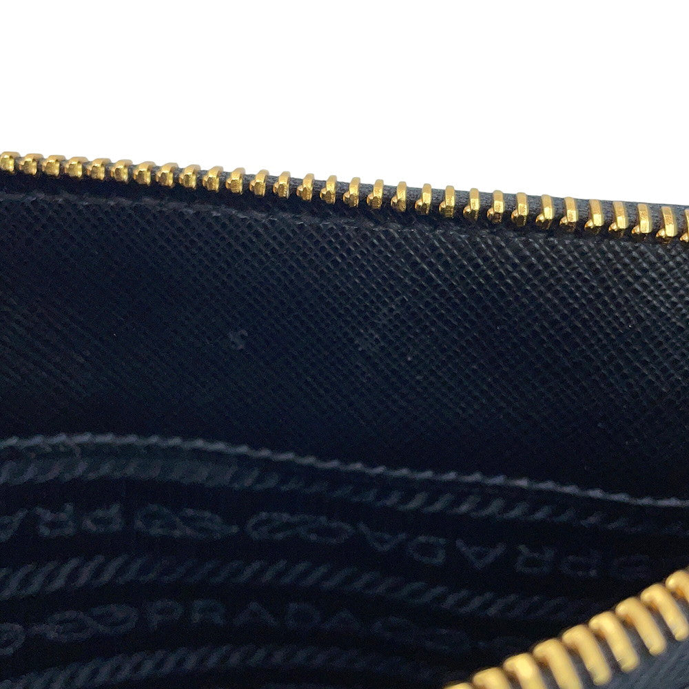 Close-up of the interior of a Prada saffiano Galleria showing black interior Bag Lining with gold-tone zipper trim and embossed Prada branding.