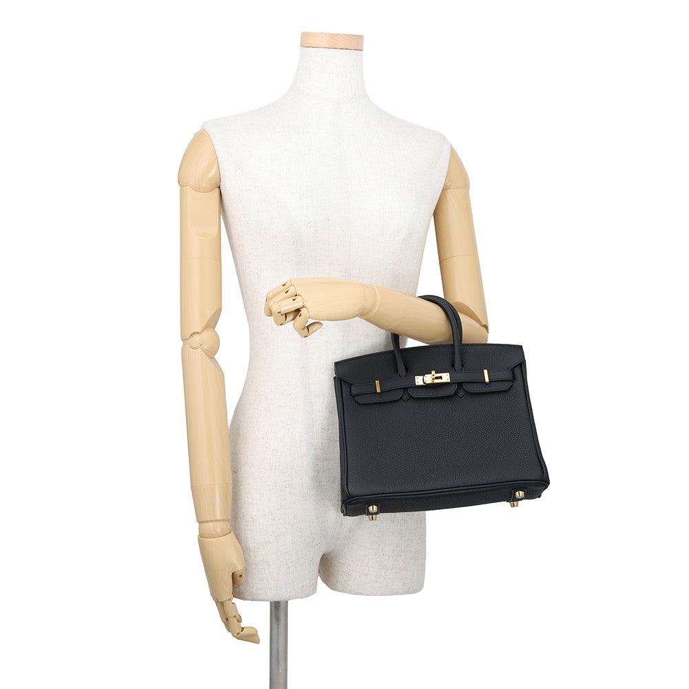 Hermès Birkin 25 in Black Togo Leather with Gold Hardware Being displayed on a mannequin arm