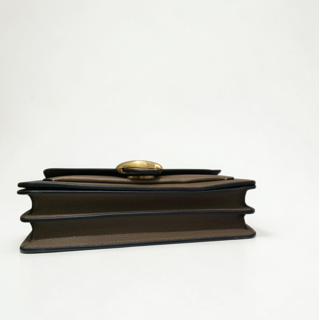 Under flap detail of COACH Tabby 26 showing magnetic snap closure and genuine pebble leather stamp