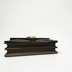 Under flap detail of COACH Tabby 26 showing magnetic snap closure and genuine pebble leather stamp
