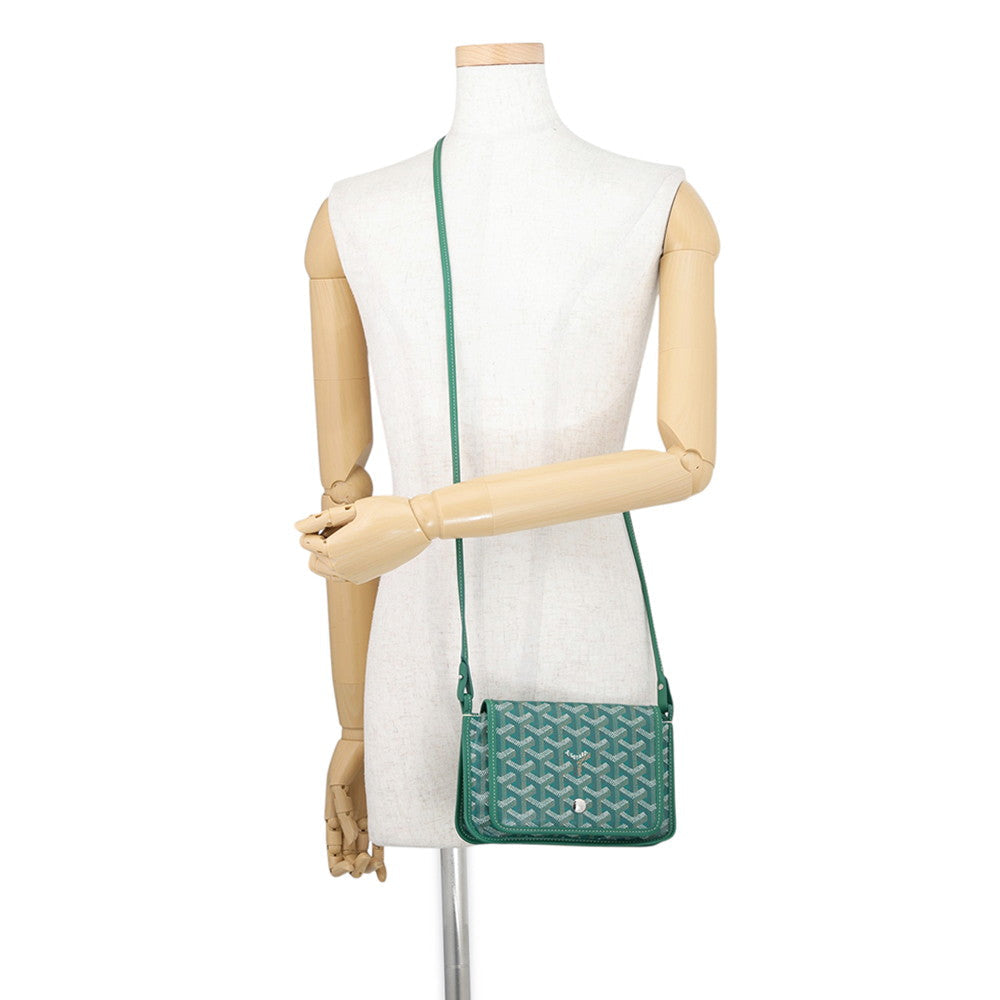 Mannequin modeling the green Goyard Plumet bag as a hands-free crossbody strap.