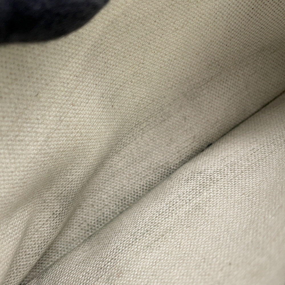 Close-up of the light off-white interior linen lining of the preowned Goyard Plumet bag.