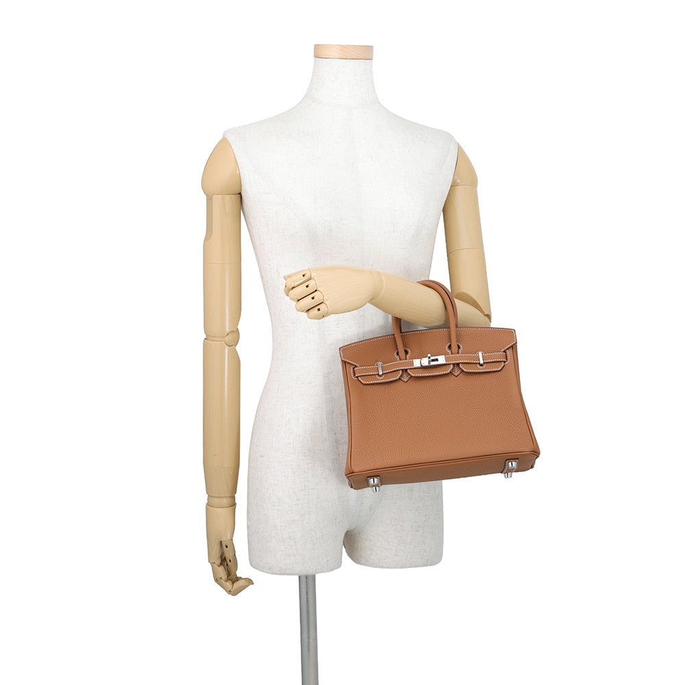 Hermès Birkin 25 in Gold Togo leather displayed on mannequin for size reference