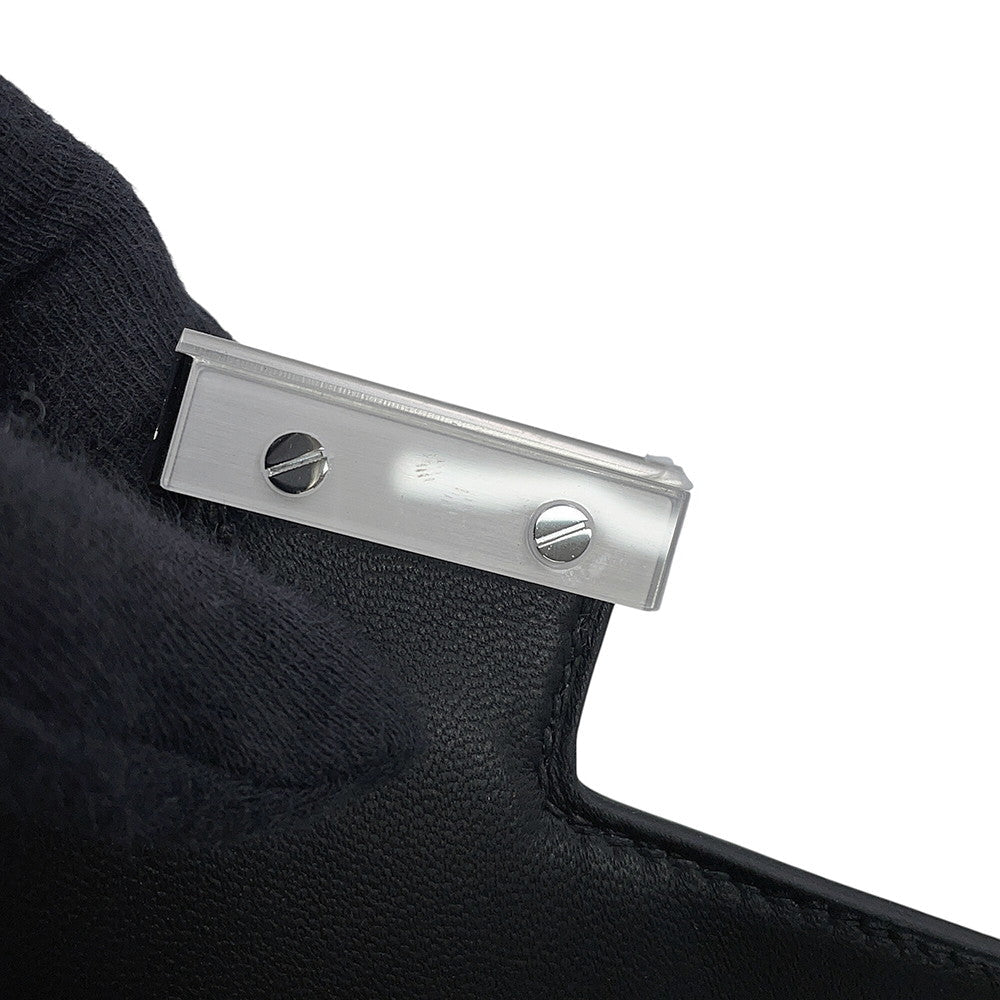 Close-up of protective plastic film on the Palladium hardware clasp of the unused Hermès Constance 18.