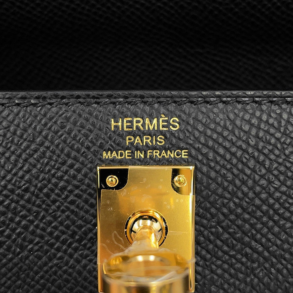 Close-up of Hermès Paris Made in France gold foil stamp and turn-lock hardware