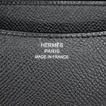 Macro detail shot of the silver foil Hermès Paris Made in France logo heat stamp on black leather.