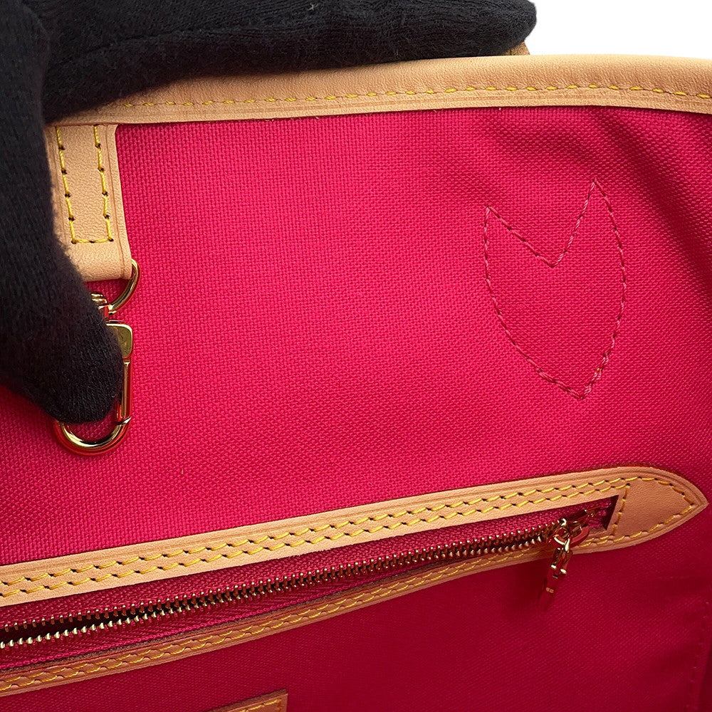 Detail of interior zip pocket and fuchsia pink textile lining on Louis Vuitton Neverfull MM