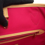 Detail of interior zip pocket and fuchsia pink textile lining on Louis Vuitton Neverfull MM