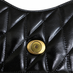 Macro view of black quilted glazed leather and signature brass C push-lock closure on the preowned bag.
